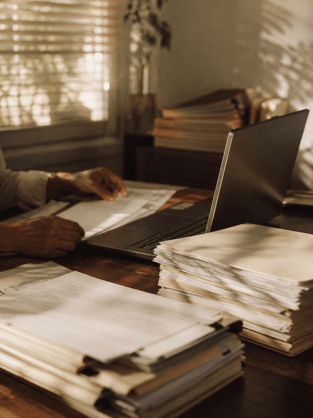 Paper claim files stacked on a desk in a regional insurance office